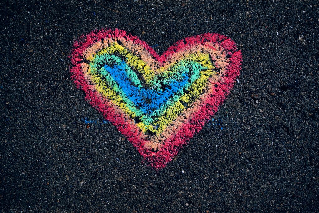 Colorful chalk heart on pavement symbolizing love and diversity for Pride.