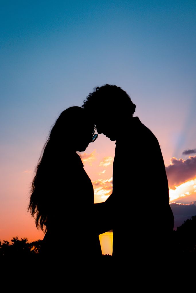 Silhouette of a couple embracing under a sunset sky, symbolizing love and connection.